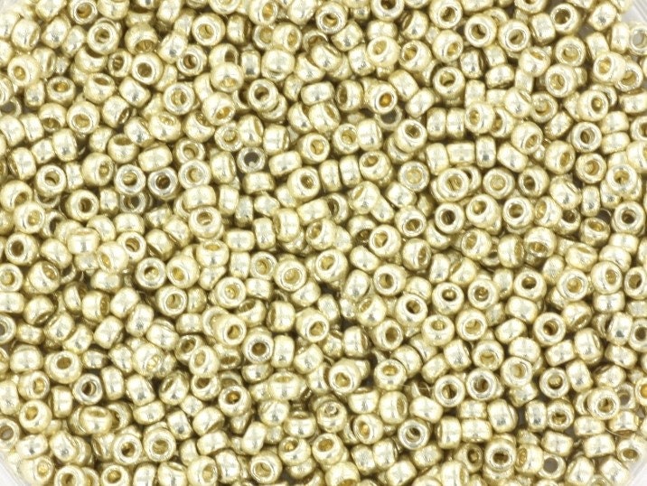 Metallic silver seed beads, 1.5mm in size and round in shape. The image is a close-up of a bowl of full of seed beads so that the beads fill the entire image