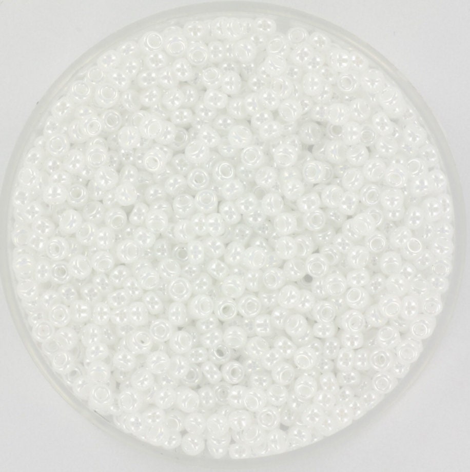 White seed beads with a shiny luster. The beads are 2mm big and round in shape.